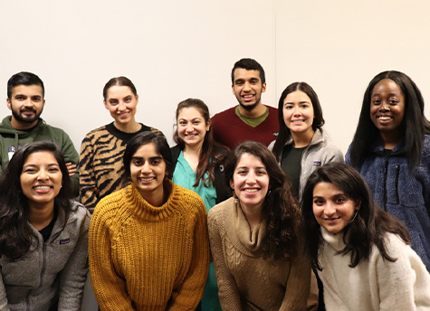 A group of ten RHP students stand together in two rows smiling at the camera.
