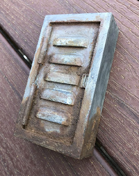 A sensor designed to look like a rusted utility box sits on top of a dark wood grain surface.